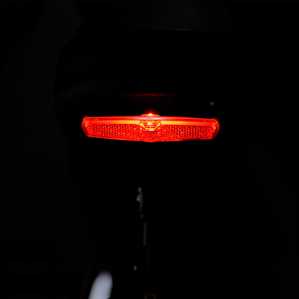 Illuminated red tail light of the Tracer Verge electric fat tire bike, providing enhanced visibility and safety during night rides, by Chico Bikes.